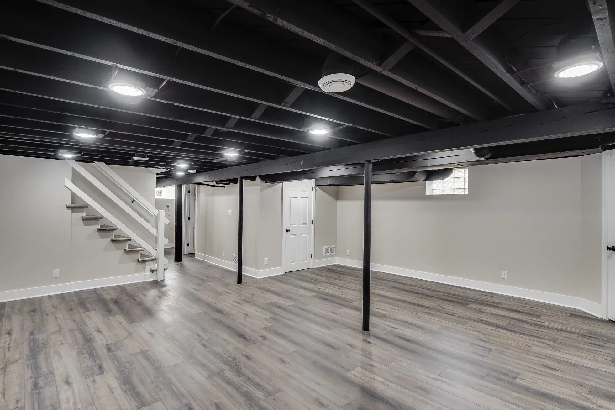 Finished basement with plank flooring, recessed lighting and a painted ceiling