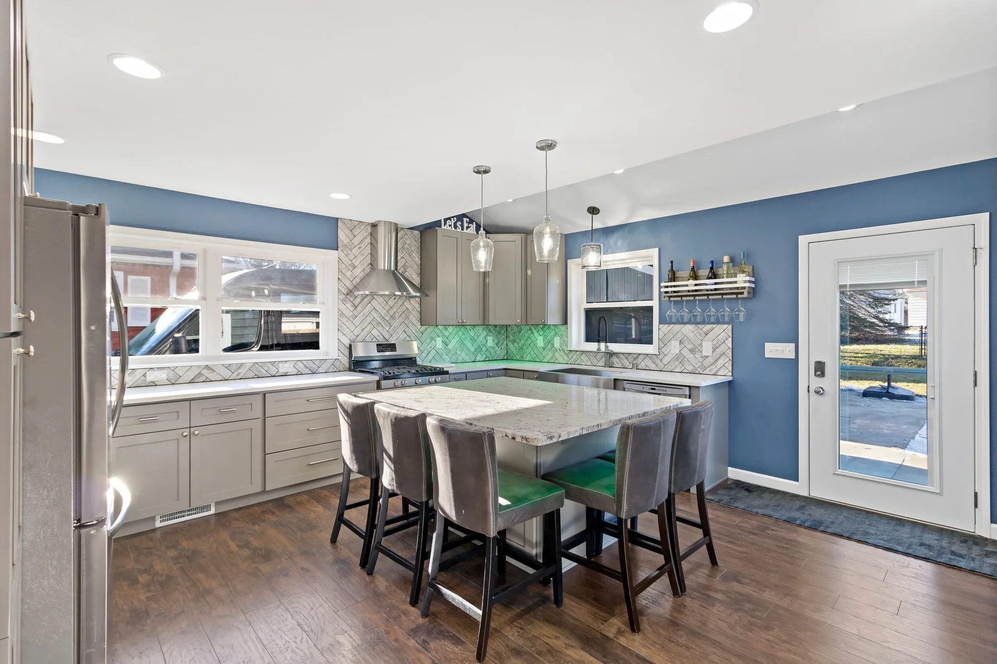 Open kitchen with an island, seating for five and a tiled backsplash